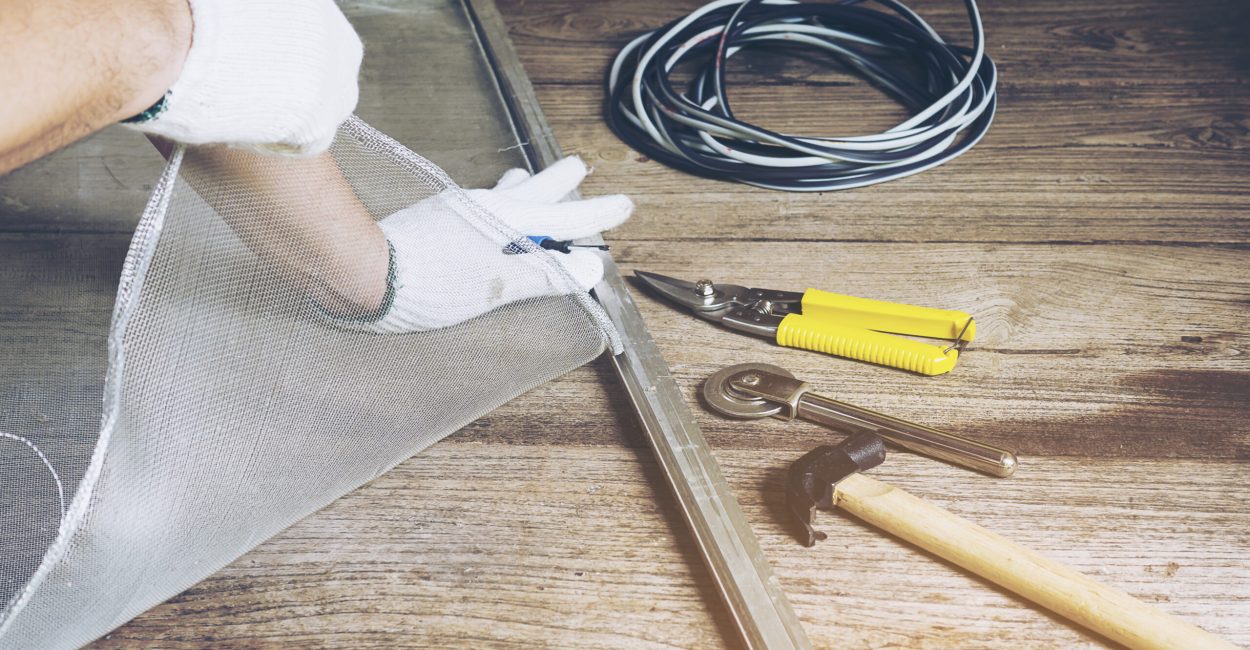 Man is working with mosquito wire screen installation